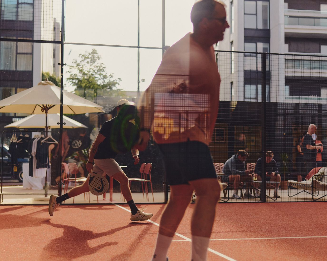 An outdoor court with spectators on the terrace